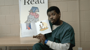 For the Family Literacy Project, this father is reading a book aloud.