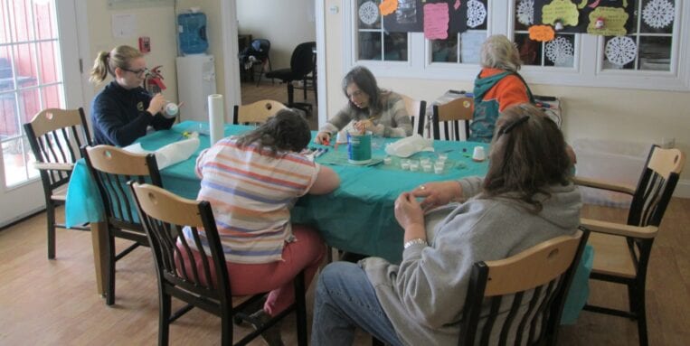 At Heritage Farm, crafters sit around a table.