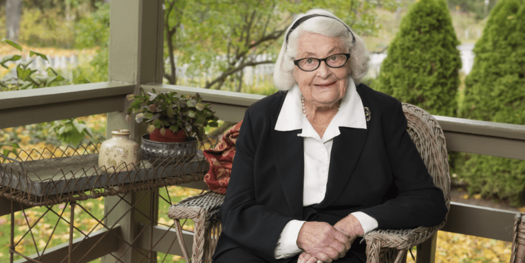 Ruth Hancock sits on the porch of her home