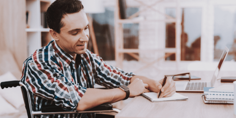 Man sitting in wheelchair writing