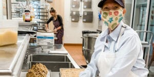 Women cooking in kitchen wearing masks