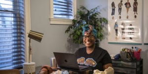 Women sits at computer smiling