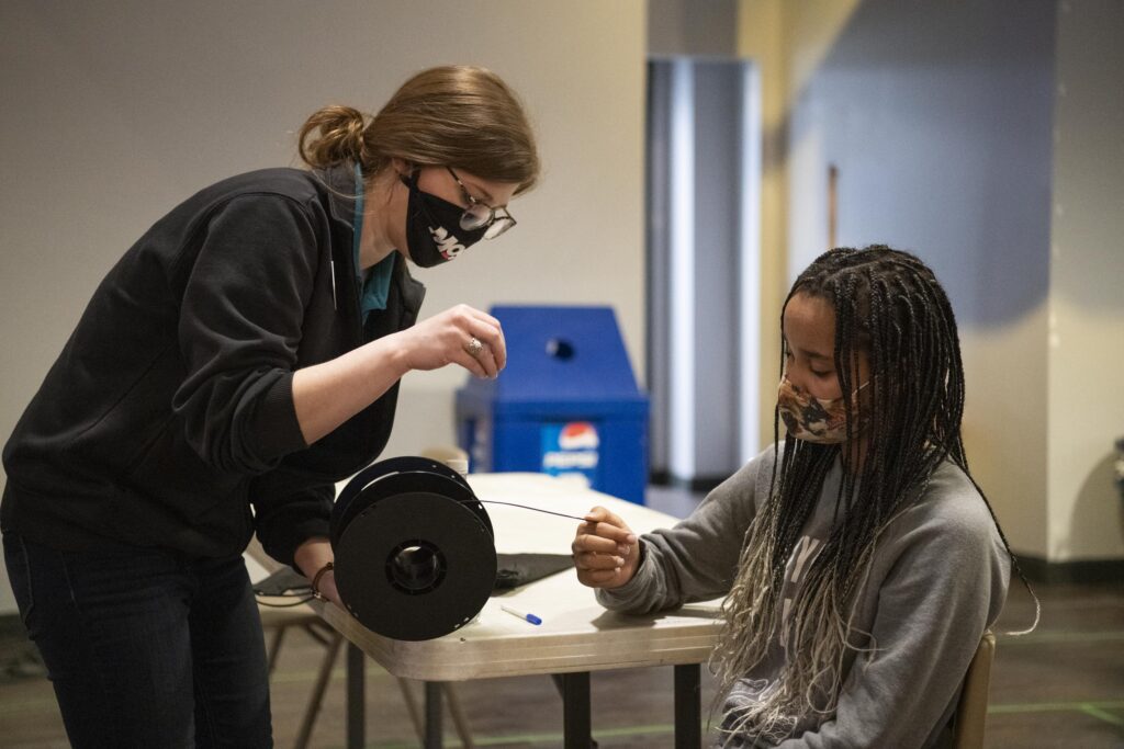 Dr. Emily Stewart demonstrates an experiment to a student. 