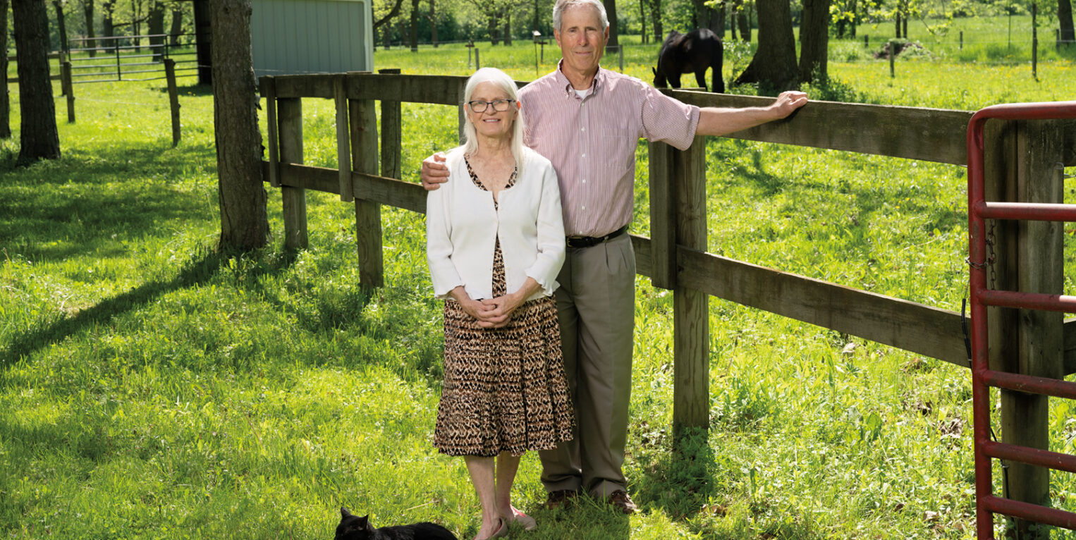 Man and woman stand outside on farm