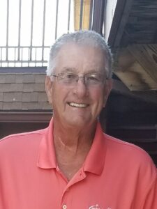 William Huther sitting in a pink shirt