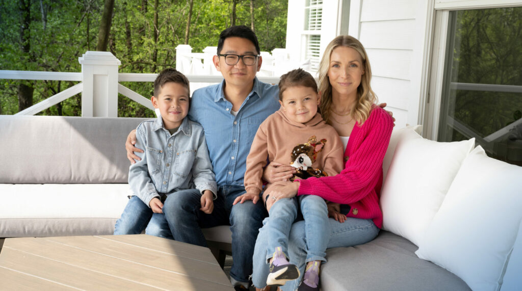 Jeff Knauss sits with his wife, son and daughter on an outdoor couch on a porch