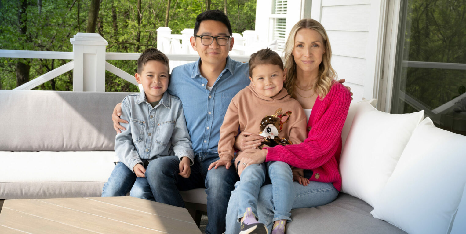 Jeff Knauss sits with his wife, son and daughter on an outdoor couch on a porch