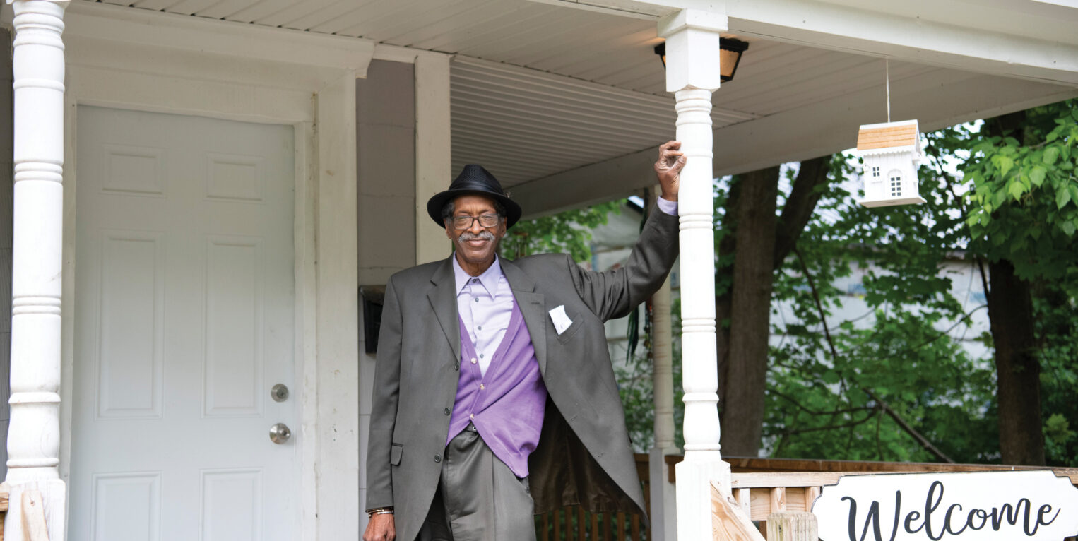 Man standing on the porch of his home