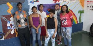 Six young people gather in front of mural at Boys & Girls Clubs