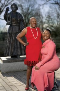 Two women in front of statue