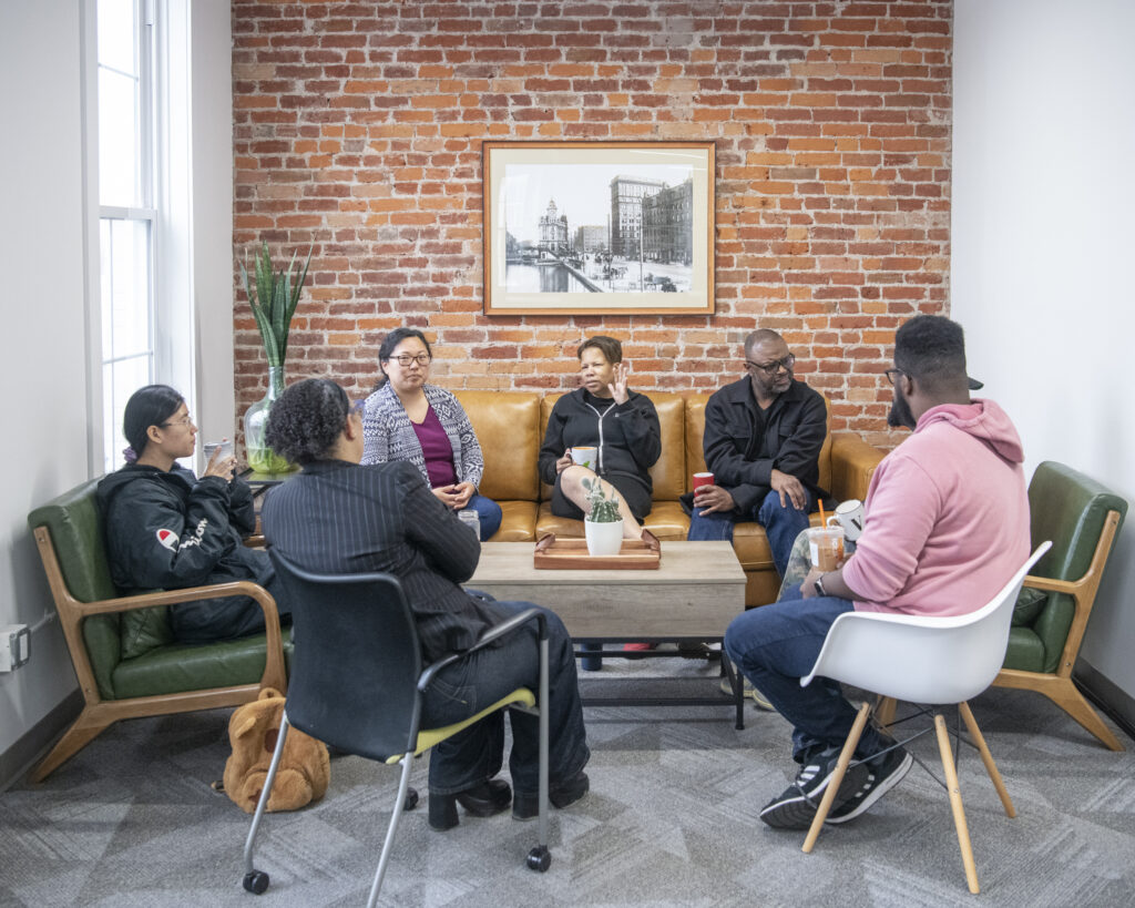 Group of people sitting and talking while drinking coffee.