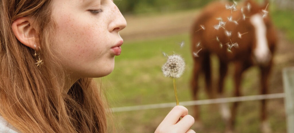 Girl blowing a dandelion