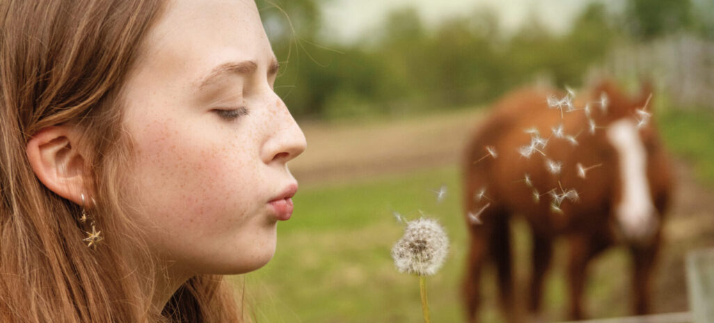 Girl blowing a dandelion
