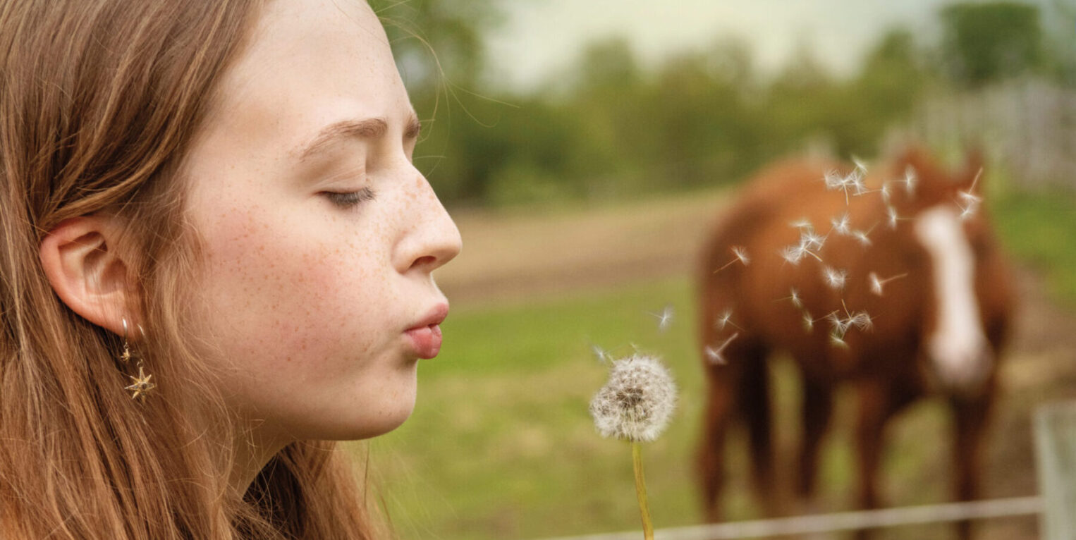 Girl blowing a dandelion