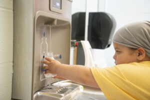 طفل يملأ زجاجة المياه عند نافورة المياه