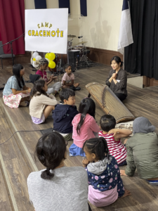 Crowd of children sitting and listening to adult instructor