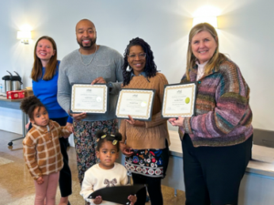 Group of people, standing and smiling with certificates