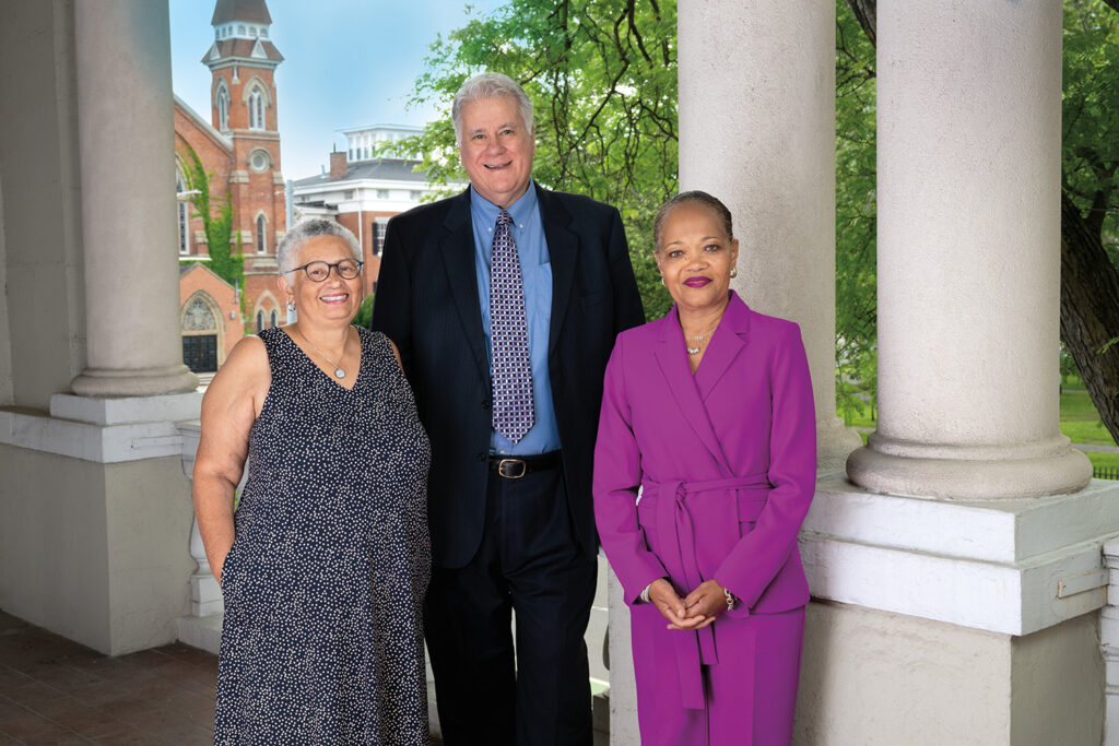 Three people standing on a balcony next to one another